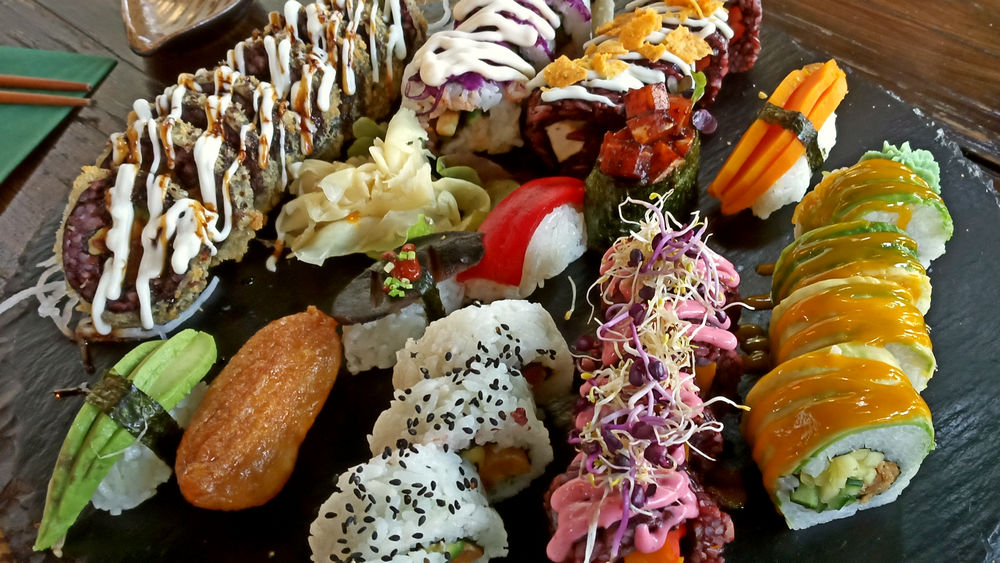 Verschiedene vegane Sushisorten auf einer Schieferplatte