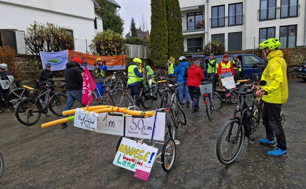 Viele Radfahrende bei Auftaktkundgebung mit Plakaten und Poolnudeln als symbolischen Abstandshalter