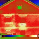 Das Wärmebild einer Hauswand mit Giebel. Deutlich zu sehen sind Wärmebrücken ober und unterhalb der Fenster.